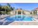 Large community pool surrounded by lounge chairs and a clubhouse with a red tile roof at 2747 Lido Key Dr, Kissimmee, FL 34747