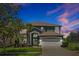 Beautiful two-story home with a well-manicured lawn, mature landscaping, and a two-car garage at 2747 Lido Key Dr, Kissimmee, FL 34747