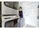 Convenient laundry area showcases a stacked washer and dryer, with storage options and an exterior door at 2747 Lido Key Dr, Kissimmee, FL 34747