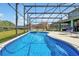 Sparkling screened pool with attached spa and backyard views with privacy fence and plenty of lounge space at 2747 Lido Key Dr, Kissimmee, FL 34747