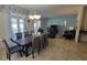 Open-concept dining room with seating for six, sliding glass doors leading to the outdoor area and view of the living room at 2952 Beach Palm Ave, Kissimmee, FL 34747