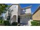 Two-story stucco home featuring a one-car garage and classic architecture at 2952 Beach Palm Ave, Kissimmee, FL 34747