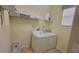 Practical laundry room with washer, dryer, storage shelves, and natural light at 2952 Beach Palm Ave, Kissimmee, FL 34747