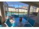 Covered patio with a view of the screened pool, complete with a dining set and loungers at 2952 Beach Palm Ave, Kissimmee, FL 34747