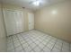 A simple bedroom with tile floors, ceiling fan, and a double door closet at 308 S Shadow Bay Dr, Orlando, FL 32825