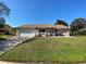 Charming single-story home with a manicured lawn, neutral paint, attached garage, and well-maintained landscaping at 308 S Shadow Bay Dr, Orlando, FL 32825