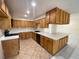 A spacious kitchen featuring wooden cabinetry, tiled countertops, and a functional layout at 308 S Shadow Bay Dr, Orlando, FL 32825