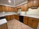 Kitchen features wood cabinets, black appliances, and tile countertops with a tile backsplash at 308 S Shadow Bay Dr, Orlando, FL 32825