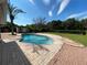 Backyard boasts a sparkling pool with brick patio, lush landscaping, and a shed, perfect for outdoor enjoyment at 308 S Shadow Bay Dr, Orlando, FL 32825
