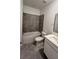 This modern bathroom features gray tiled walls, a shower-tub combination, a toilet, and a vanity at 312 Nine Iron Dr, Davenport, FL 33896