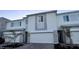 View of a well kept townhome with gray brick features, white garage door, and green plants at 312 Nine Iron Dr, Davenport, FL 33896