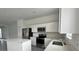 A bright, modern kitchen features stainless steel appliances, white cabinets, and a center island at 312 Nine Iron Dr, Davenport, FL 33896