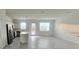 Open-concept living room with a modern kitchen featuring stainless steel appliances and tile flooring at 312 Nine Iron Dr, Davenport, FL 33896