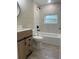Stylish bathroom boasts marble tiling, tub, and contemporary vanity with storage space at 3135 Old Dixie Hwy, Auburndale, FL 33823