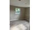Neutral bedroom with light gray wood flooring and natural light from one window at 3135 Old Dixie Hwy, Auburndale, FL 33823
