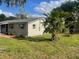 Single-story home with a well-manicured lawn, trees and gray shutters at 3135 Old Dixie Hwy, Auburndale, FL 33823