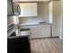 The kitchen has new appliances, white cabinets, a microwave, and light wood-look vinyl flooring at 3135 Old Dixie Hwy, Auburndale, FL 33823
