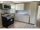 The kitchen has new appliances, white cabinets, a microwave, and light wood-look vinyl flooring at 3135 Old Dixie Hwy, Auburndale, FL 33823