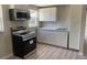 The kitchen has new appliances, white cabinets, a microwave, and light wood-look vinyl flooring at 3135 Old Dixie Hwy, Auburndale, FL 33823