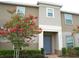 Charming two-story home featuring a blooming tree, blue front door, and well-maintained landscaping at 314 Annabelle Way, Davenport, FL 33837
