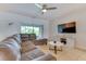 Comfortable living room with a sectional sofa, a mounted TV, and sliding glass doors to the outside at 314 Annabelle Way, Davenport, FL 33837