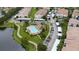 Aerial view of a pool surrounded by lush landscaping, residences, and parking at 3300 Whitestone Cir # 201, Kissimmee, FL 34741