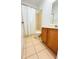 A bathroom featuring a shower-tub combo, ceramic tile flooring, and a wooden vanity at 3300 Whitestone Cir # 201, Kissimmee, FL 34741