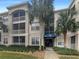 Three-story condo building with a blue awning over the entrance and several palm trees on the property at 3300 Whitestone Cir # 201, Kissimmee, FL 34741
