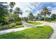 Exterior shot of the Flora Ridge Condominium entrance featuring landscaping and palm trees at 3300 Whitestone Cir # 201, Kissimmee, FL 34741