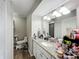 Bright bathroom featuring a granite vanity, decorative mirror, and a toilet in a separate alcove at 340 Vail Dr, Winter Haven, FL 33884