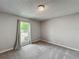 Neutral bedroom featuring grey carpet and walls and a window with curtains and a view of the neighborhood at 340 Vail Dr, Winter Haven, FL 33884