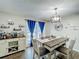 Cozy dining room with a wooden table, neutral chairs, a stylish chandelier, and a bar cabinet at 340 Vail Dr, Winter Haven, FL 33884