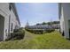 Townhome backyard featuring green grass, manicured landscaping, and fenced common area at 3470 Beau Rd, Kissimmee, FL 34746