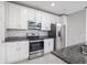 Stylish kitchen featuring stainless steel appliances, granite countertops, and white cabinetry at 3470 Beau Rd, Kissimmee, FL 34746