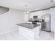 Bright kitchen features an island, white cabinets, stainless steel appliances, and modern lighting at 3470 Beau Rd, Kissimmee, FL 34746