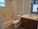 Bathroom featuring tiled shower-tub, wood vanity, and grey countertop at 36 Inconnu Dr, Poinciana, FL 34759