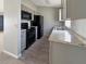 Modern kitchen with black appliances, gray cabinets, granite countertops and wood-look tile floors at 36 Inconnu Dr, Poinciana, FL 34759