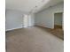 Inviting living area with tan carpet, sliding glass doors, neutral walls and a contemporary chandelier at 36 Inconnu Dr, Poinciana, FL 34759