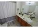 Well-lit bathroom featuring a decorative shower curtain and wooden cabinets at 4004 Santa Maria Dr # 108, Kissimmee, FL 34741