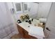 Well-lit bathroom showcasing a vanity with a mirror, towels, and decorative flowers at 4004 Santa Maria Dr # 108, Kissimmee, FL 34741