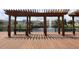 A pergola with benches overlooks a serene pond and neighborhood at 4004 Santa Maria Dr # 108, Kissimmee, FL 34741