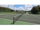 Outdoor tennis court next to a scenic pond and lush landscaping at 4004 Santa Maria Dr # 108, Kissimmee, FL 34741