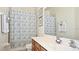 Bright bathroom showcasing a wood vanity with marble countertop, a framed mirror, and a shower with a patterned curtain at 4072 Oaktree Dr, Davenport, FL 33837