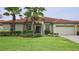Inviting single-story home with mature landscaping, manicured lawn, and a terracotta tiled roof at 4072 Oaktree Dr, Davenport, FL 33837