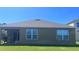 Rear exterior view of home featuring covered patio, manicured lawn and ample backyard space at 4147 Sherlock Ct, Orlando, FL 32824