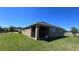Backyard featuring a covered patio, lush green lawn, and partial view of neighboring homes at 4147 Sherlock Ct, Orlando, FL 32824