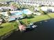 Aerial view of a lakeside community pier featuring boat slips, covered gazebo, and nearby clubhouse at 4907 Romeo Cir, Kissimmee, FL 34746