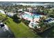 Aerial view of a community pool featuring a large sun deck, water features, and nearby lake at 4907 Romeo Cir, Kissimmee, FL 34746