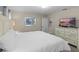 Comfortable bedroom featuring a queen bed, dresser with a TV, and light neutral decor at 4907 Romeo Cir, Kissimmee, FL 34746