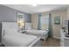 This bedroom features two twin beds, bedside table, neutral walls and blue decorative curtains and artwork at 4907 Romeo Cir, Kissimmee, FL 34746